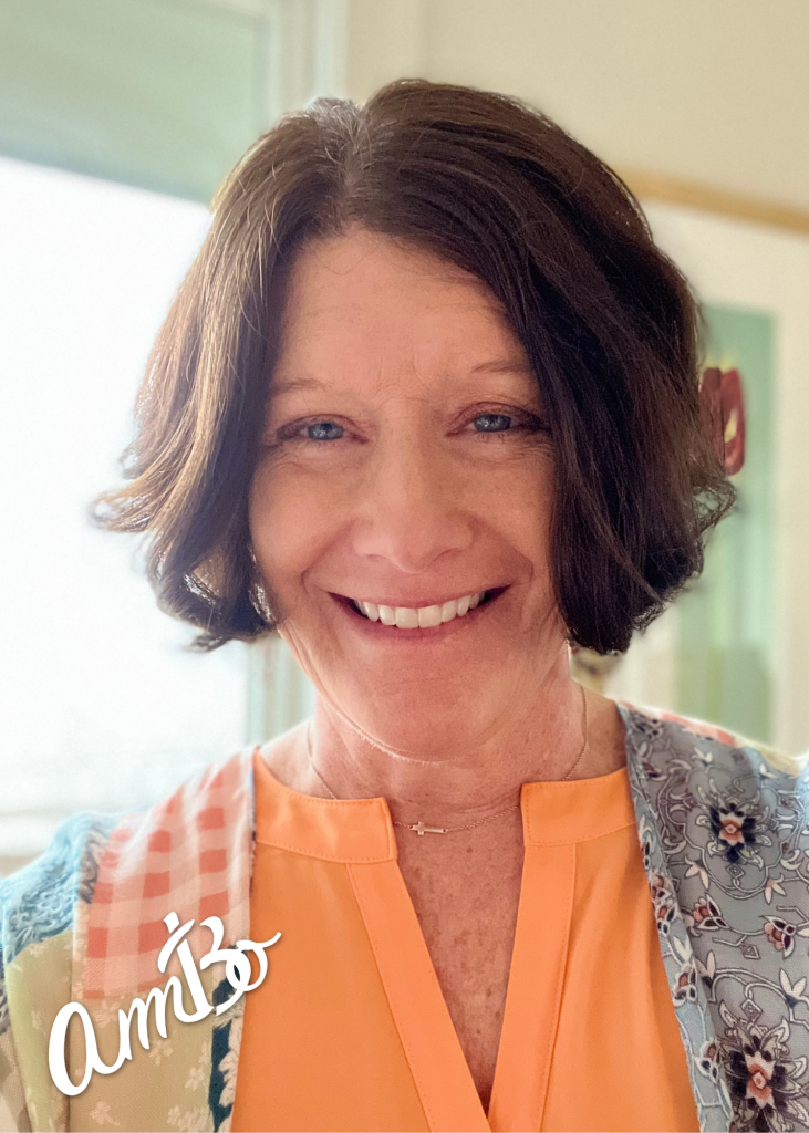 A woman with short hair wearing an orange shirt.