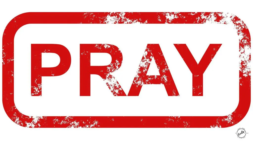 A red and white sign that says pray.