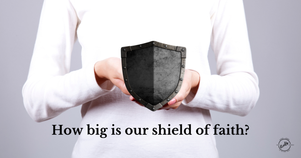 A woman holding a black shield with the words " how big is our shield of faith ?" underneath it.