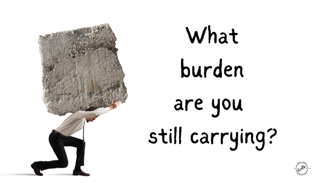 A man carrying a large rock with the words " what burden are you still carrying ?" underneath.