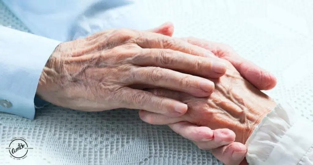 A close up of an old person 's hands on top of another older person