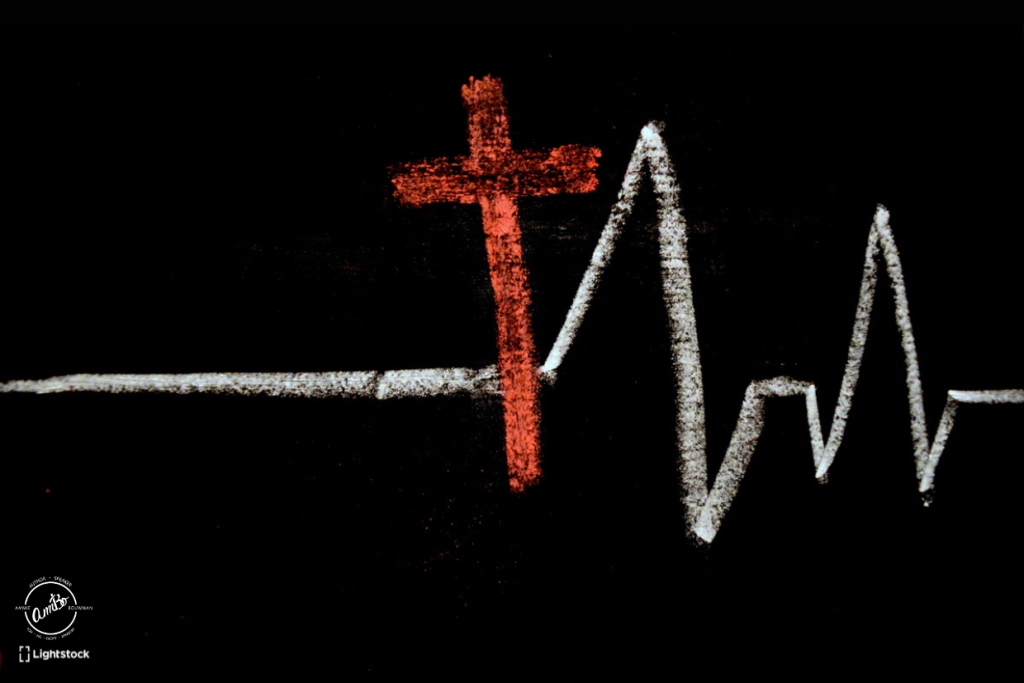 A cross and an ecg line drawn on paper.