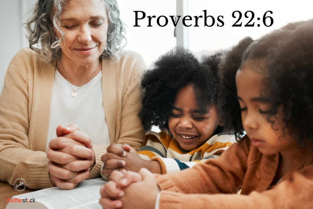 A woman and two children are praying together.