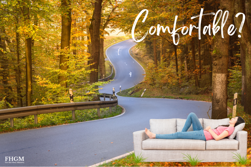 A woman sitting on the couch in front of a road.