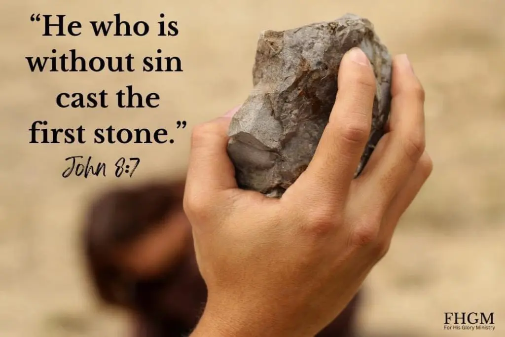 A person holding onto a rock with the bible verse john 8 : 7