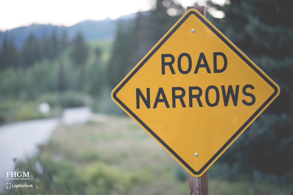 A yellow road sign sitting on top of a wooden pole.